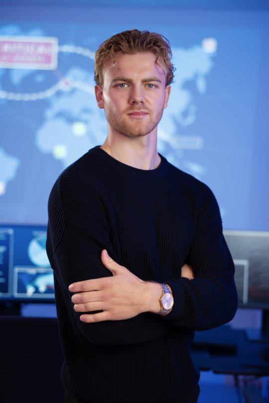 Male Cybersecurity Analyst in large Cyber Security Operation Center SOC handling Threats